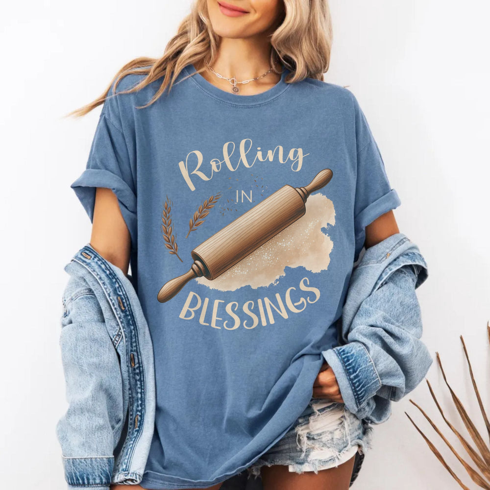 Person wearing a blue t-shirt with 'Rolling in Blessings' graphic design.