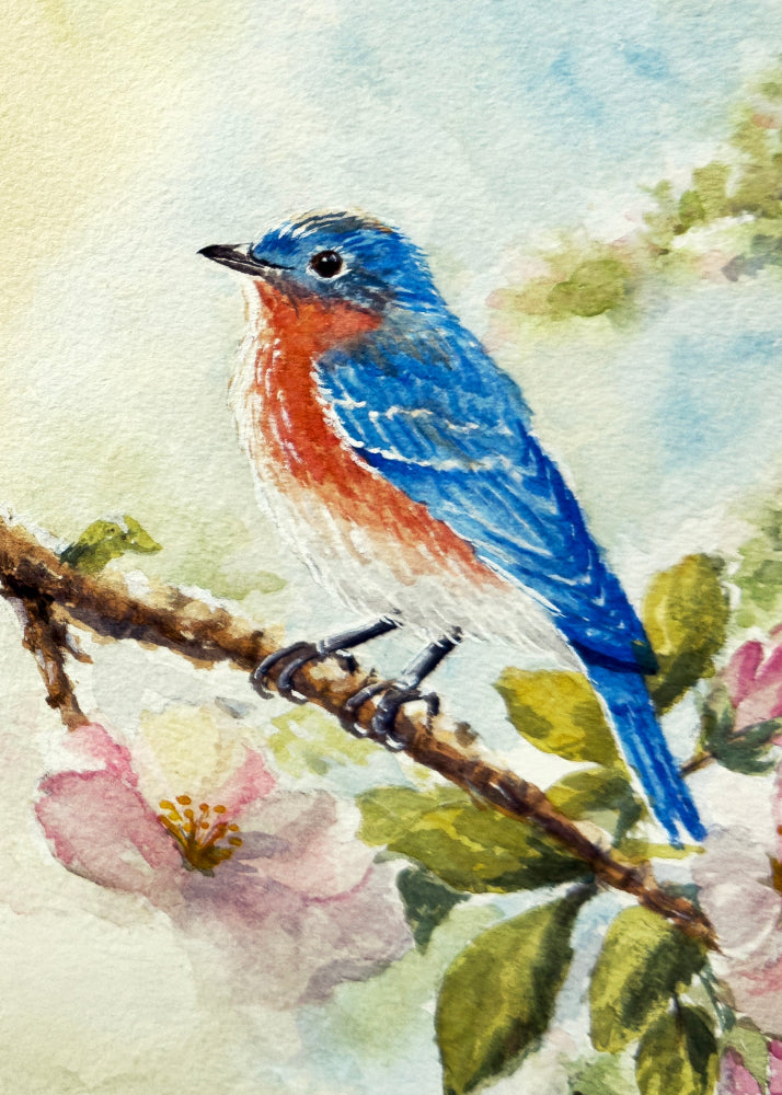 Watercolor painting of a bluebird perched on a branch with pink blossoms and green leaves against a soft pastel background.