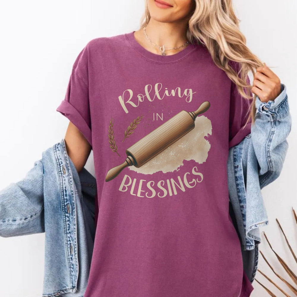 Person wearing a purple t-shirt with a graphic and text 'Rolling in Blessings'.